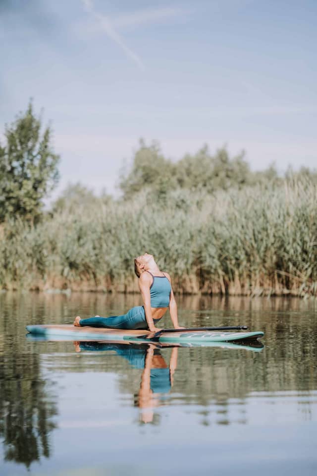 Woman Practicing Yoga On Paddleboard