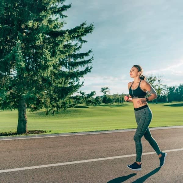 Woman Jogging Outdoors In Sunny Park