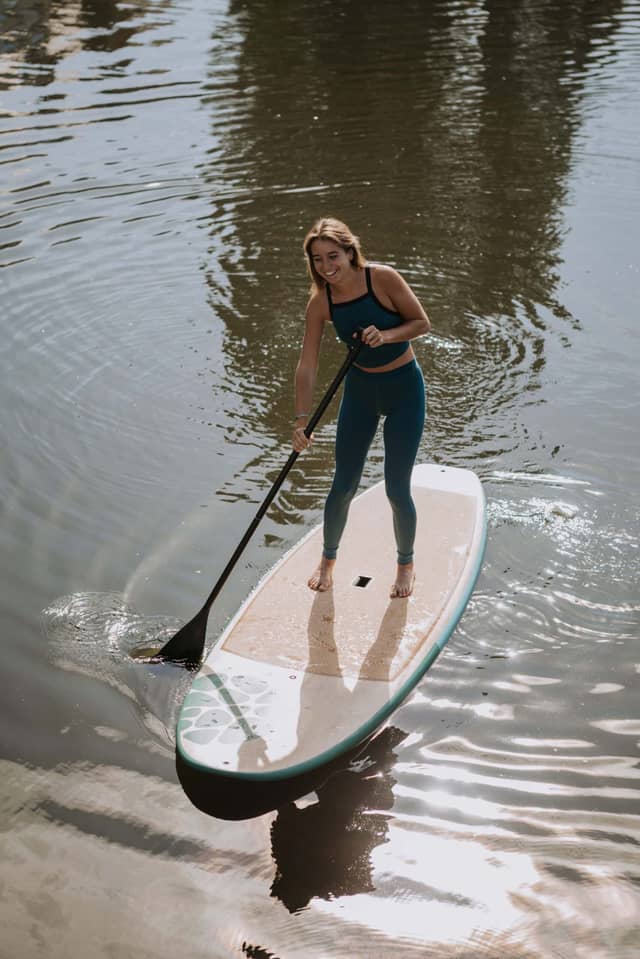 Woman Paddle Boarding On Cork Surface