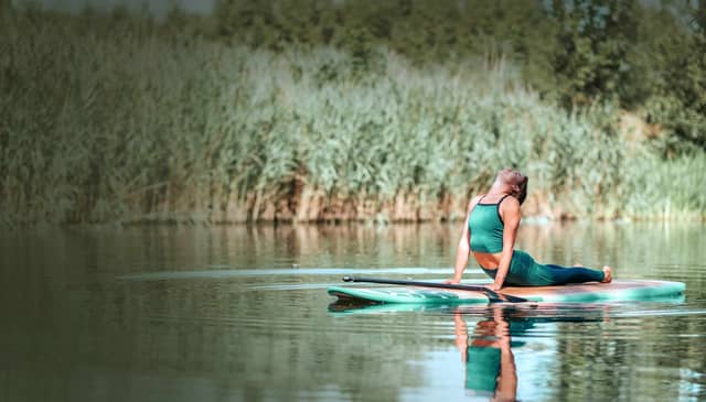 Woman Practicing Yoga On Paddle Board