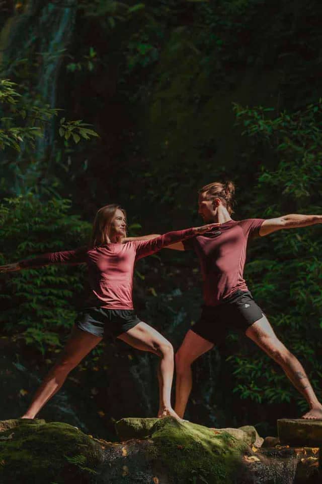 People Practicing Warrior Two Yoga Pose Outdoors