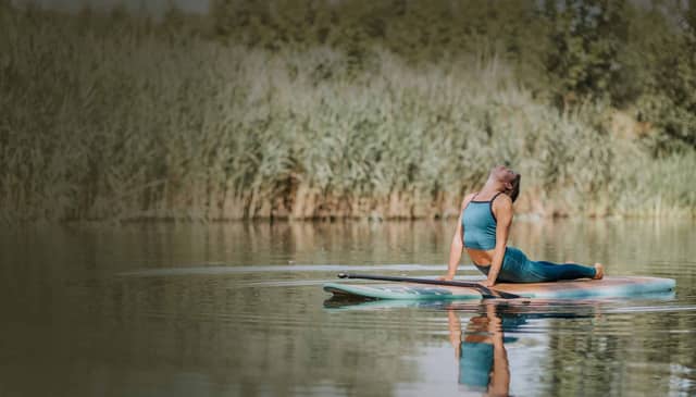 Woman Practicing Yoga On Paddleboard