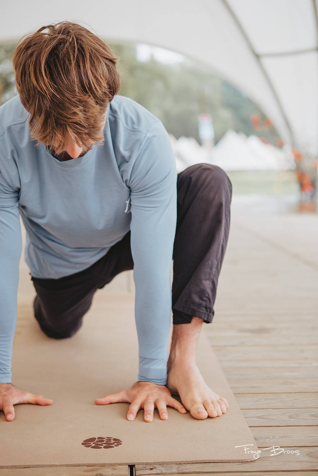 Man practising on a cork yoga mat on an outdoor deck