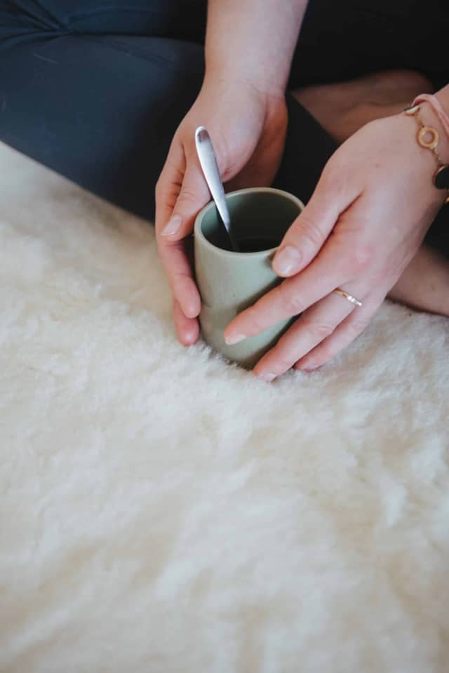 Woman Holding Cup On Soft Wool Rug