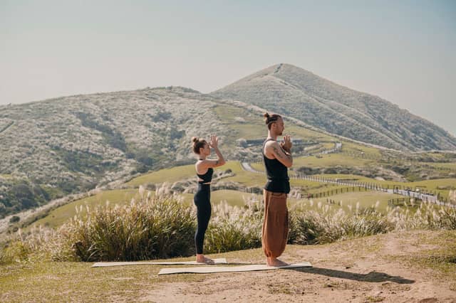 People Practicing Yoga In The Hills