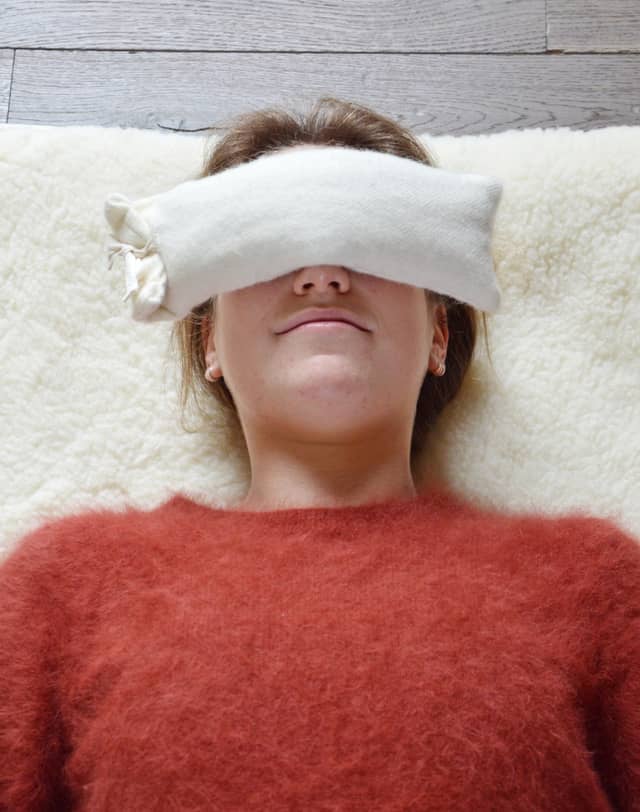 Woman Practicing Savasana With Eye Pillow