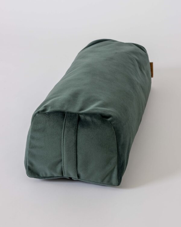 A dark green velvet Pierre Sports yoga bolster with a carrying handle on a white background.